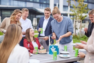 Mitarbeitende essen und trinken gemeinsam im Mitarbeiterpark im Atrium am Standort RVK